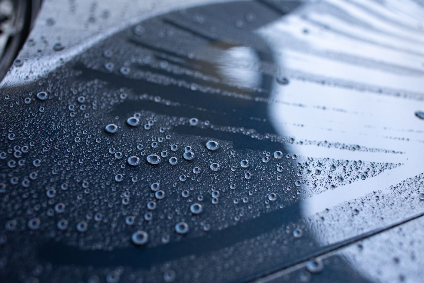 Water beading on a ceramic-coated black car