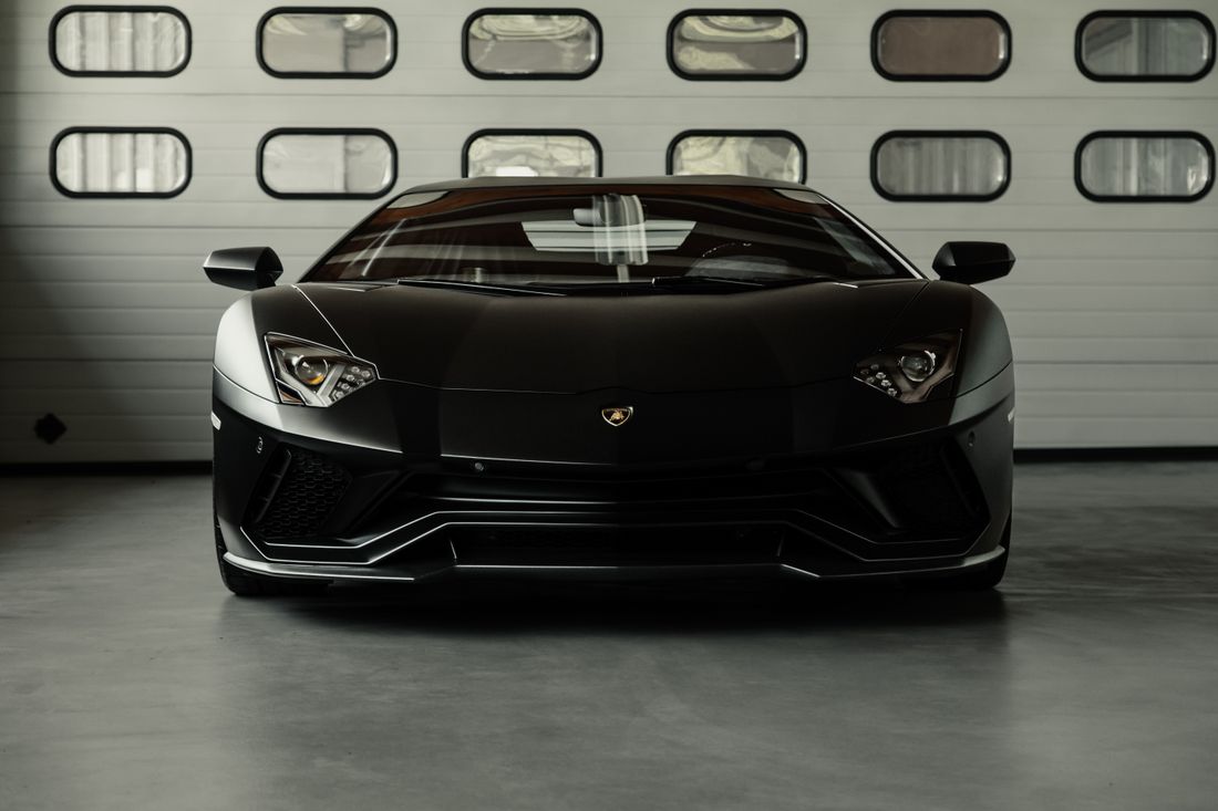 Black supercar in a studio after detailing